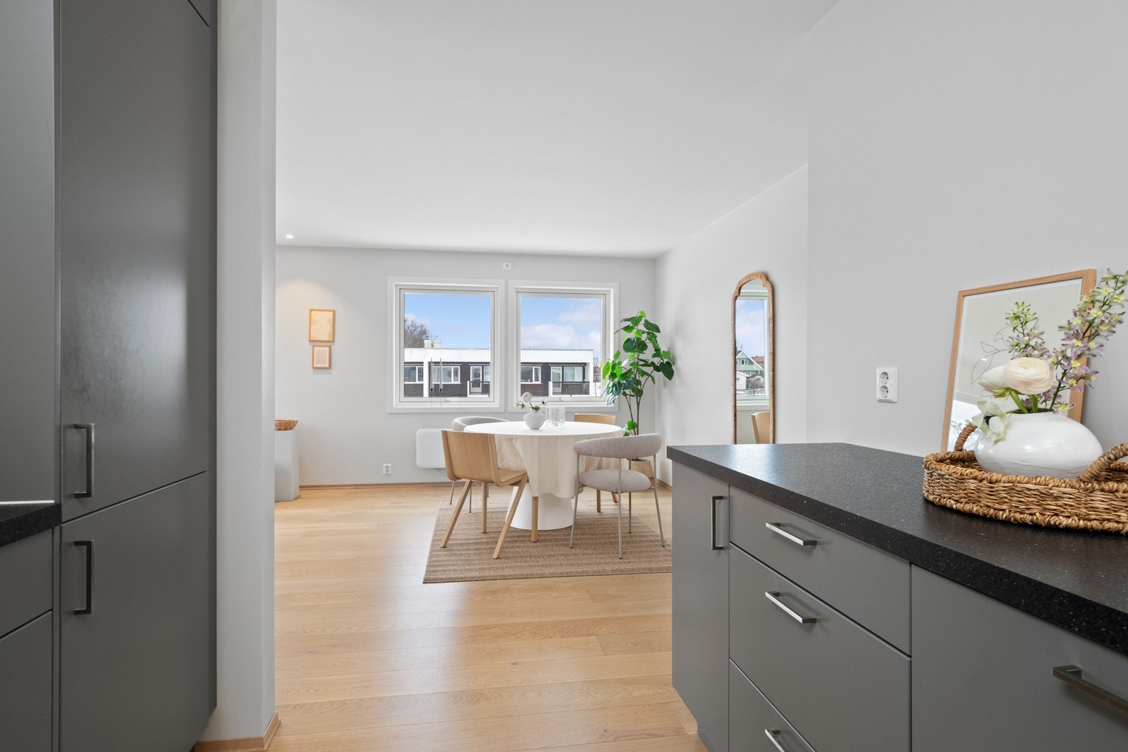 Innredningen har grå, glatte fronter, vitrinedører, takhøye skap og koksgrå, noe tykkere laminatbenkeplate med nedfelt kum. Galleribilde