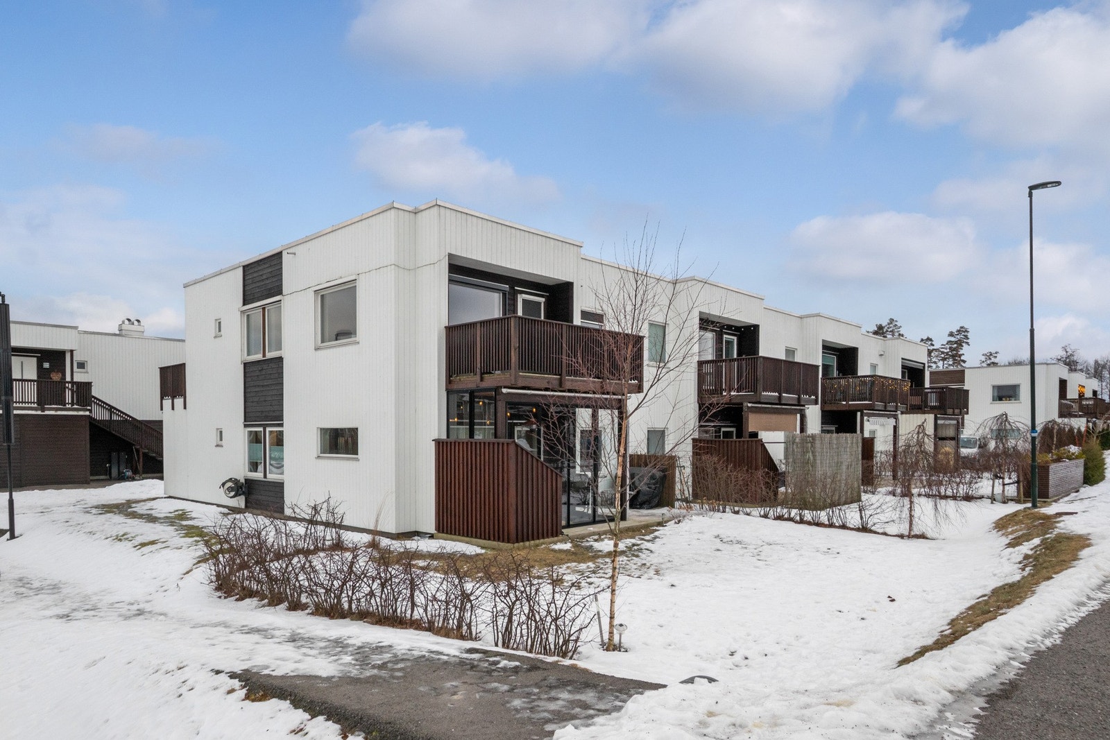 Fellestomten er pent opparbeidet med plenarealer, prydbusker og asfalterte internveier. Galleribilde