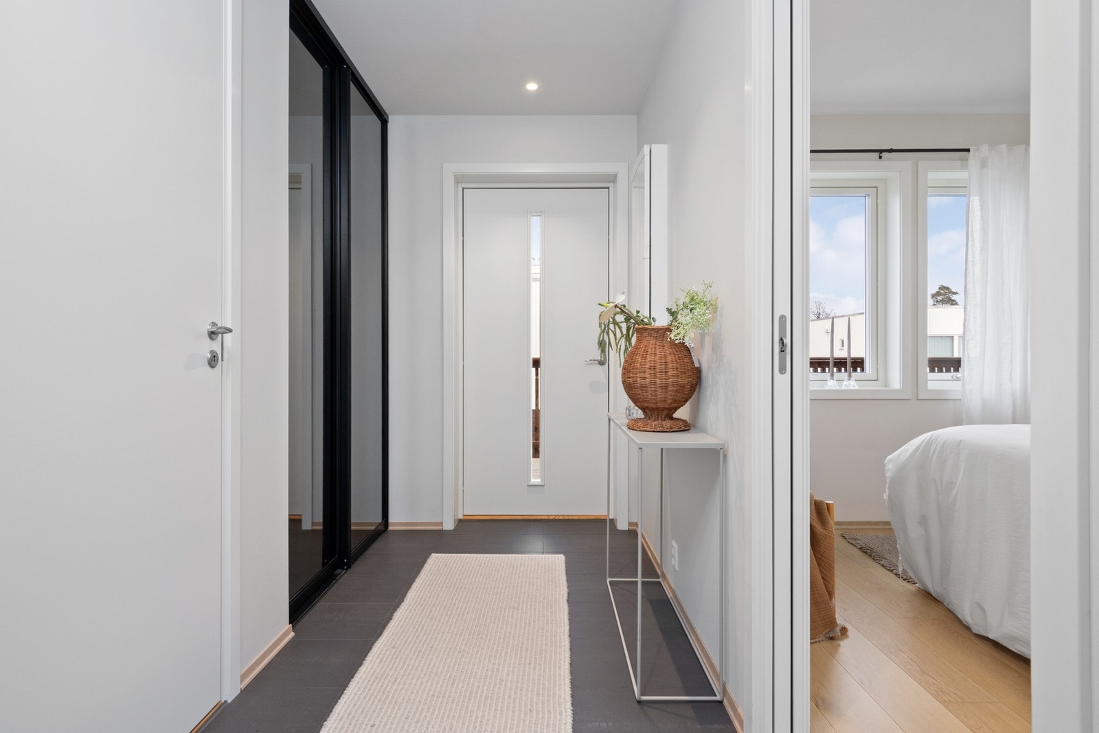 Yttertøy, sko og utstyr ryddes enkelt bort i en plassbygd skyvedørsgarderobe med speilfronter. Galleribilde