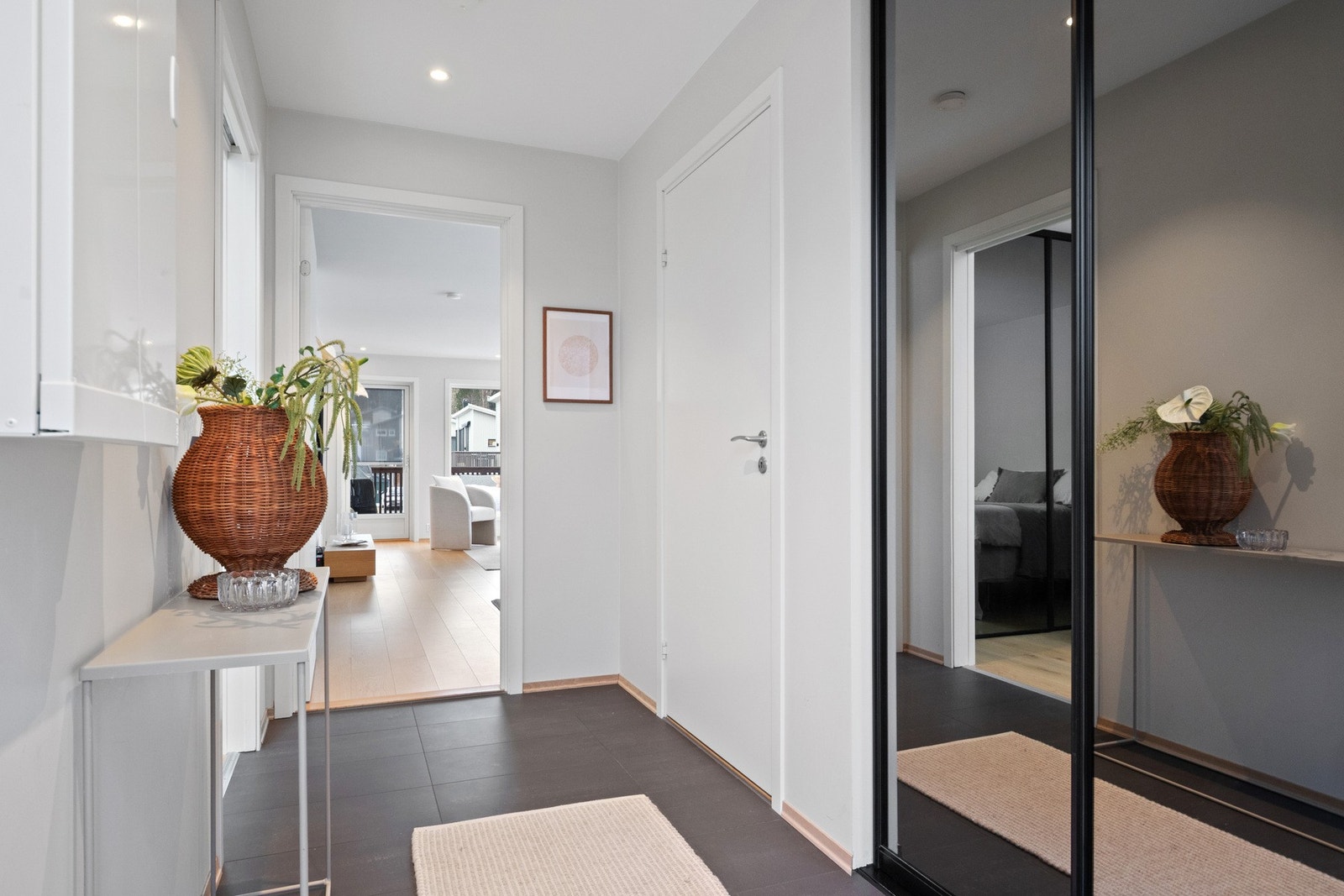 Pen entré med hvitmalte vegger, downlights i himlingen og grå fliser på gulv med gulvvarme. Galleribilde