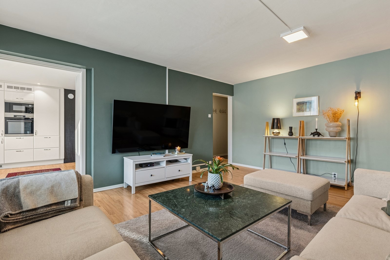 Stue med gjennomgående lys, harmoniske fargetoner og utsikt mot omgivelsene gjennom store vinduer. Galleribilde