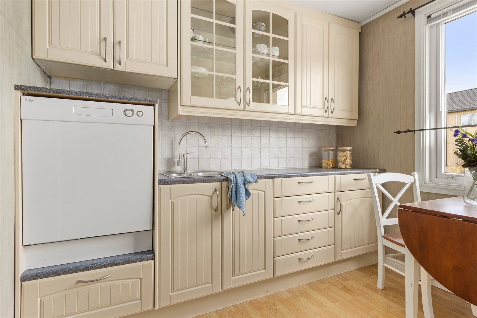 Kjøkkenet er av god størrelse med innredning langs to vegger, og plass for frokostbordet under vindu. Innredningen strekker seg til tak, og har godt med oppbevaringsplass. Ekstra praktisk med plass avsatt til oppvaskmaskinen som er i arbeidshøyde. Galleribilde