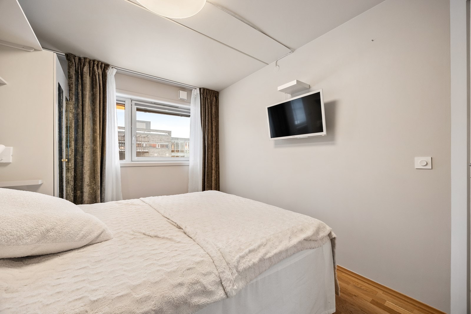 Rommet er holdt i nøytrale farger og har plass til TV. Galleribilde