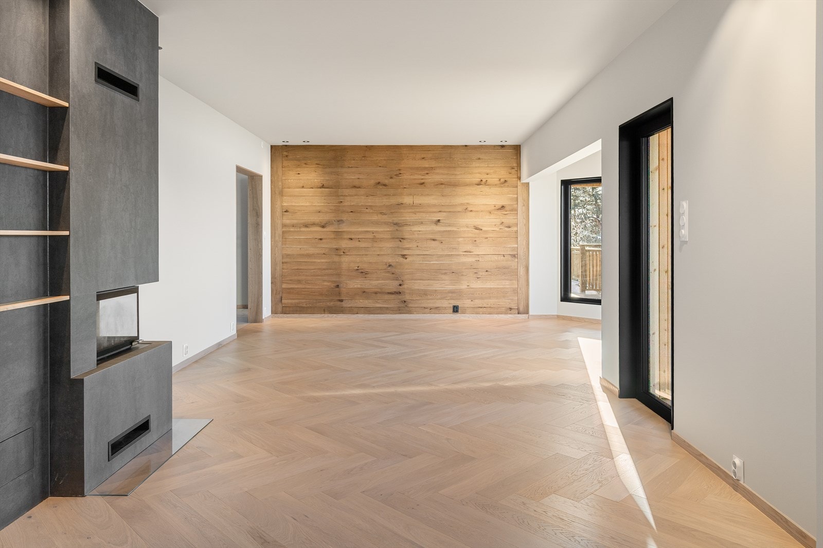 Boligen har en stor stuesone med store vindusflater, fiskebeinsgulv og malte flater på vegger. Galleribilde