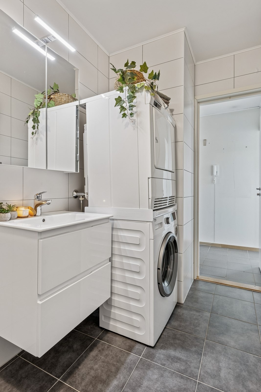 Badet har en praktisk innredning med servantmøbel, speilskap og opplegg for vaskesøyle. Galleribilde