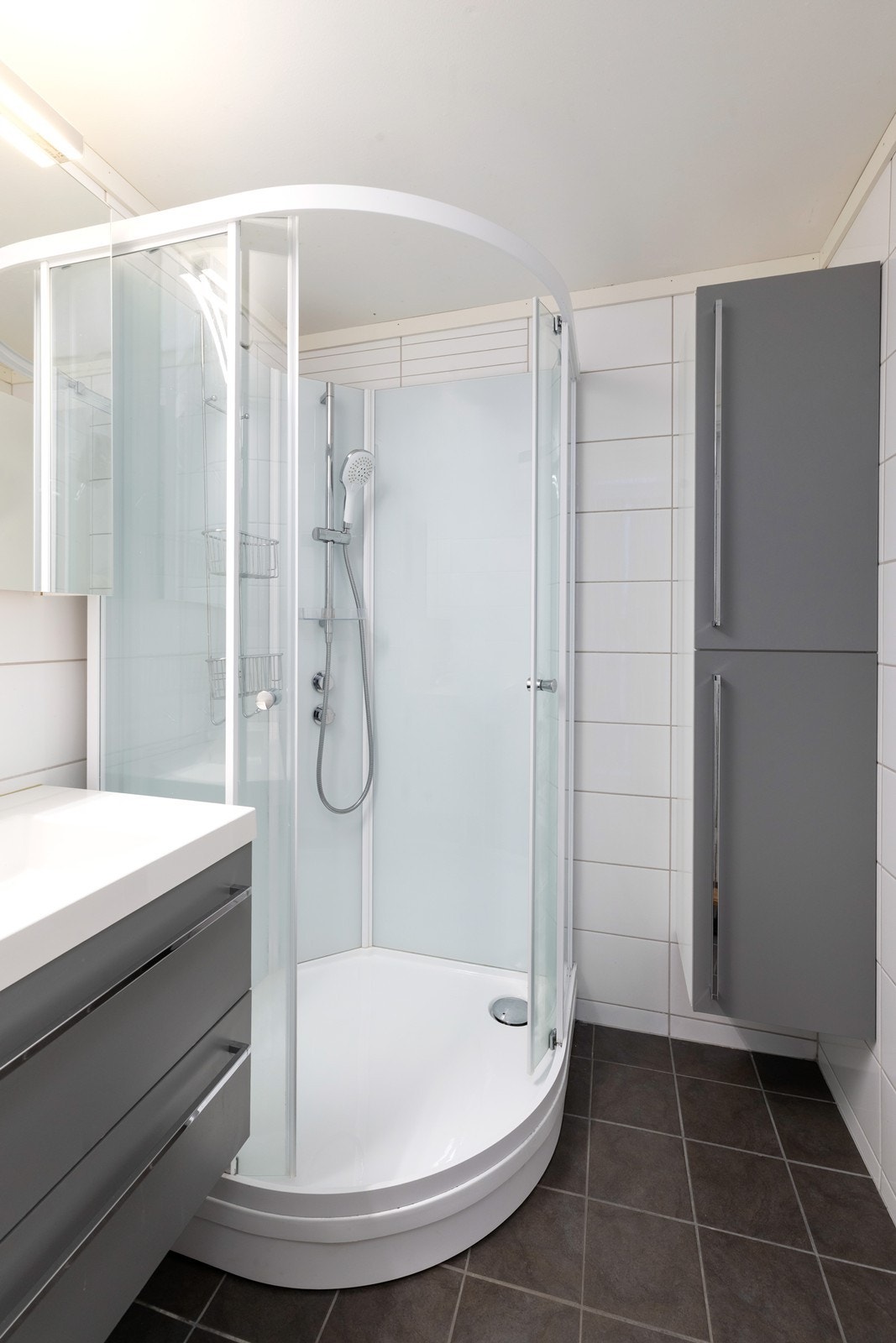 Badet har dusjkabinett samt servant med overspeil og underskap. Galleribilde