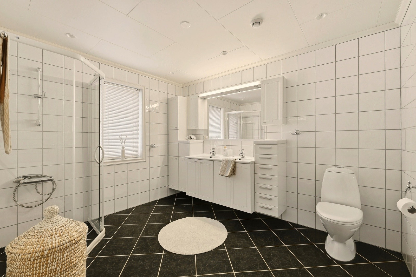 Det er to bad i huset og et romslig vaskerom. Dette badet har god størrelse og en tidløs stil. Galleribilde