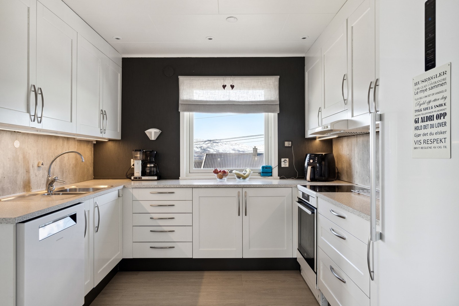 U-formet kjøkkeninnredning med mye skap- og benkeplass Galleribilde