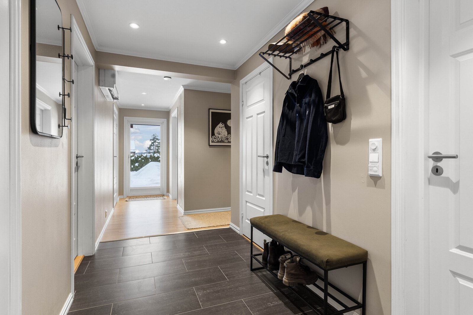 Veggene er malt i en delikat beige tone. Her er det god plass til både yttertøy og sko. Galleribilde