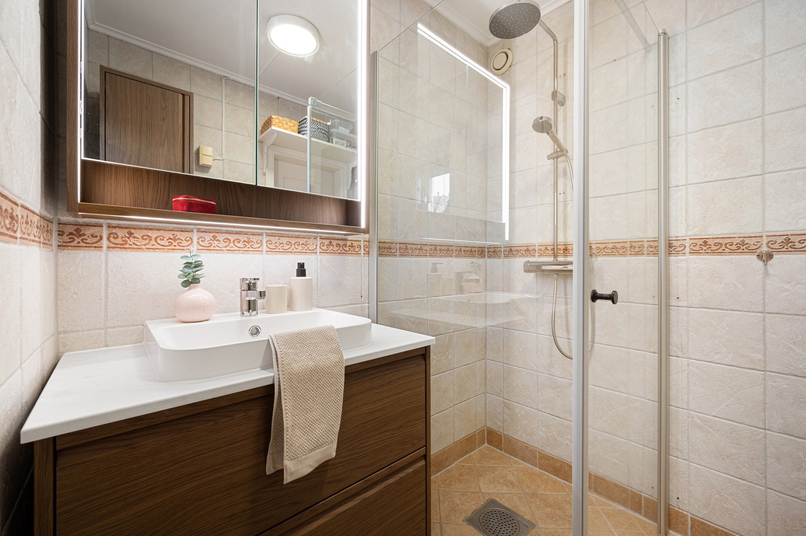 Badet er innredet med dusjhjørnet, servant på underskap og speilskap. Galleribilde