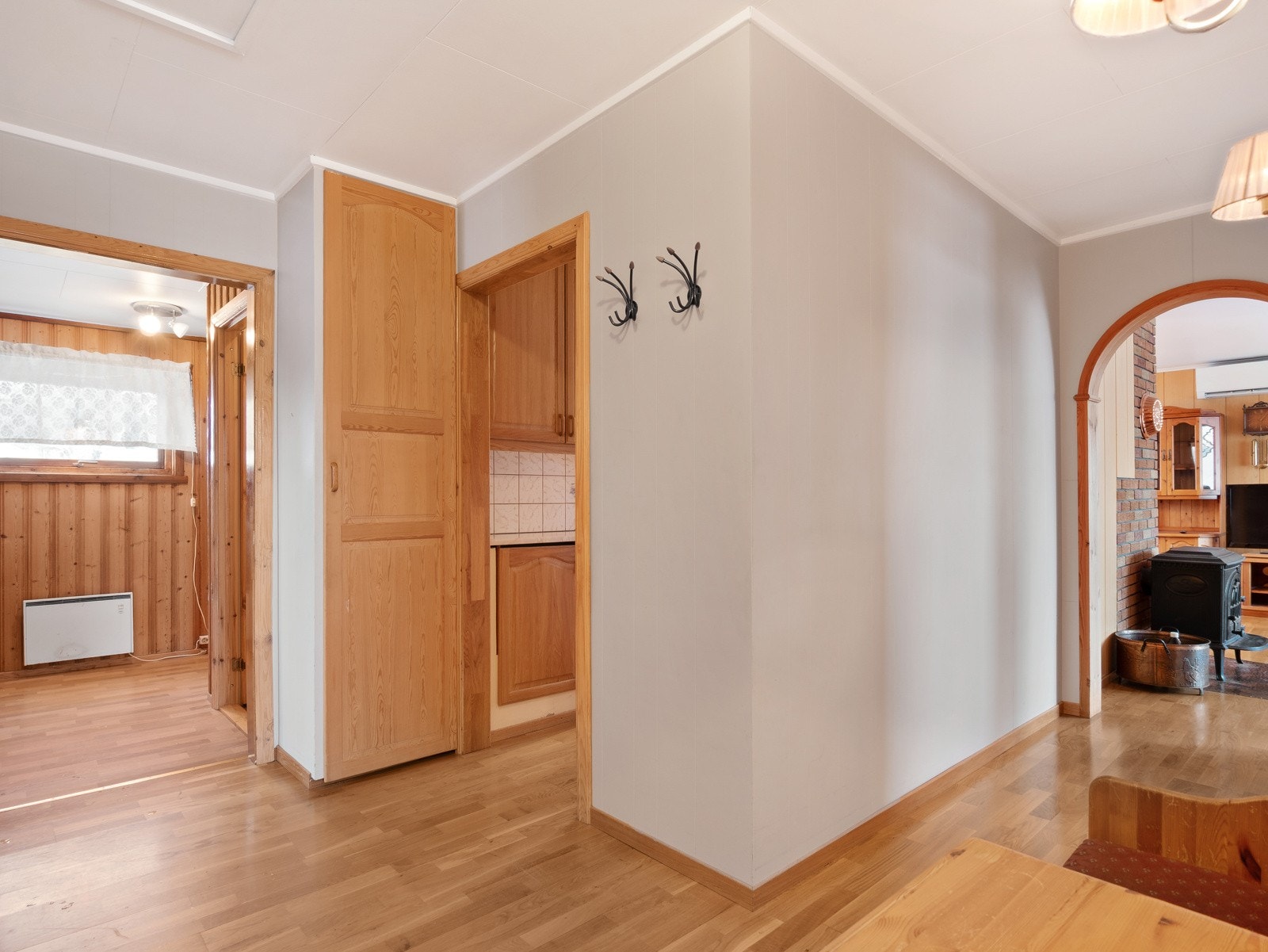 Oversiktsbilde gang med vindfang, inngang til kjøkken og portal mot stue Galleribilde