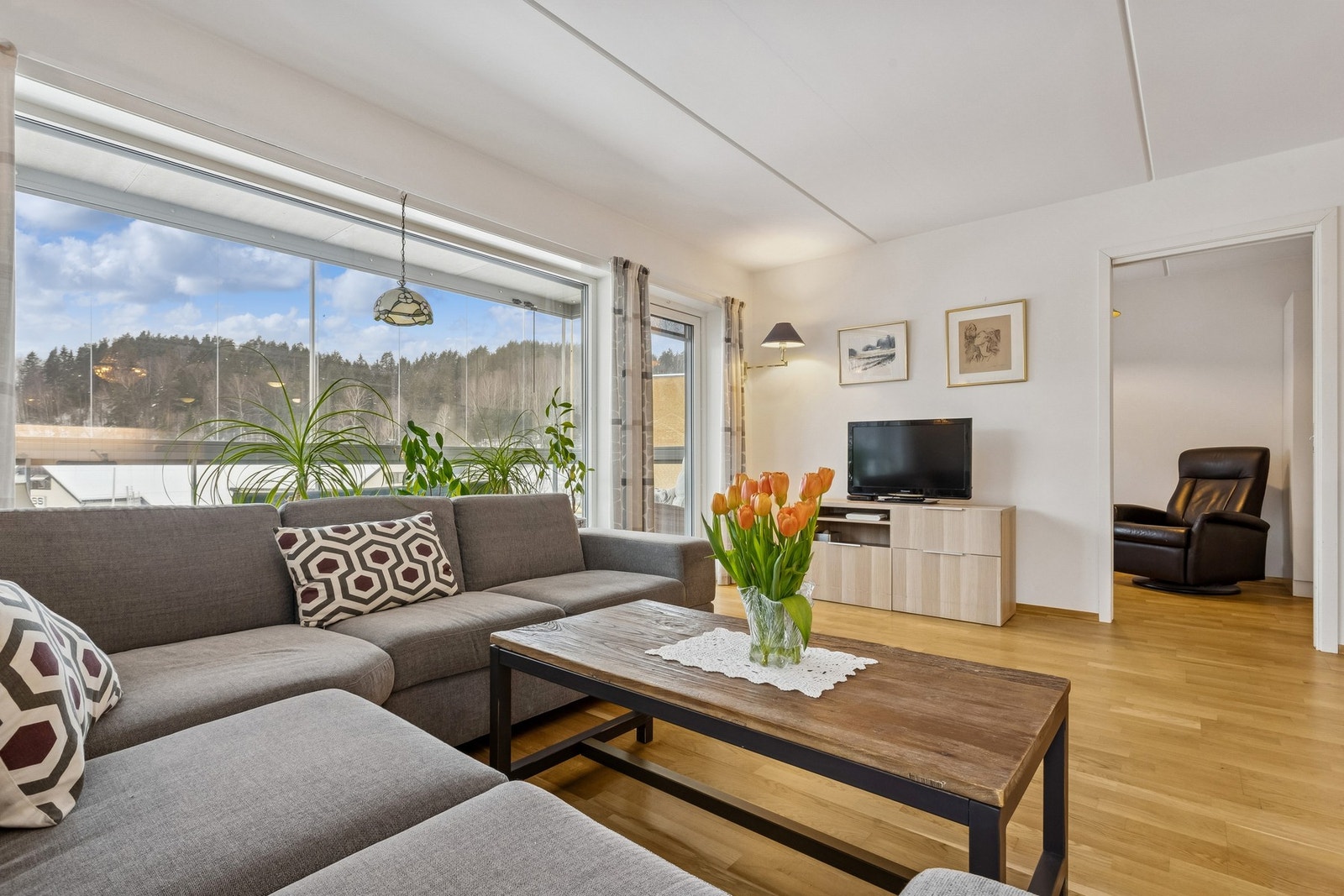 Romslig stue med store lysfalter fra to himmelretninger Galleribilde