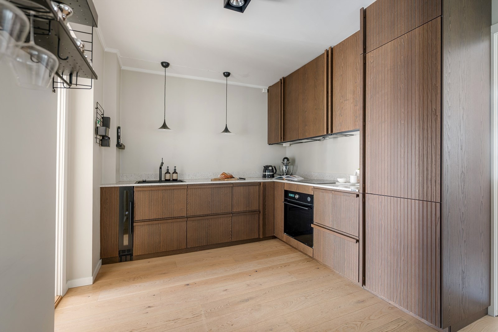 Stilrent kjøkken med finér fronter og Granitop benkeplate i steinkompositt med planlimt kum i kompositt. Galleribilde