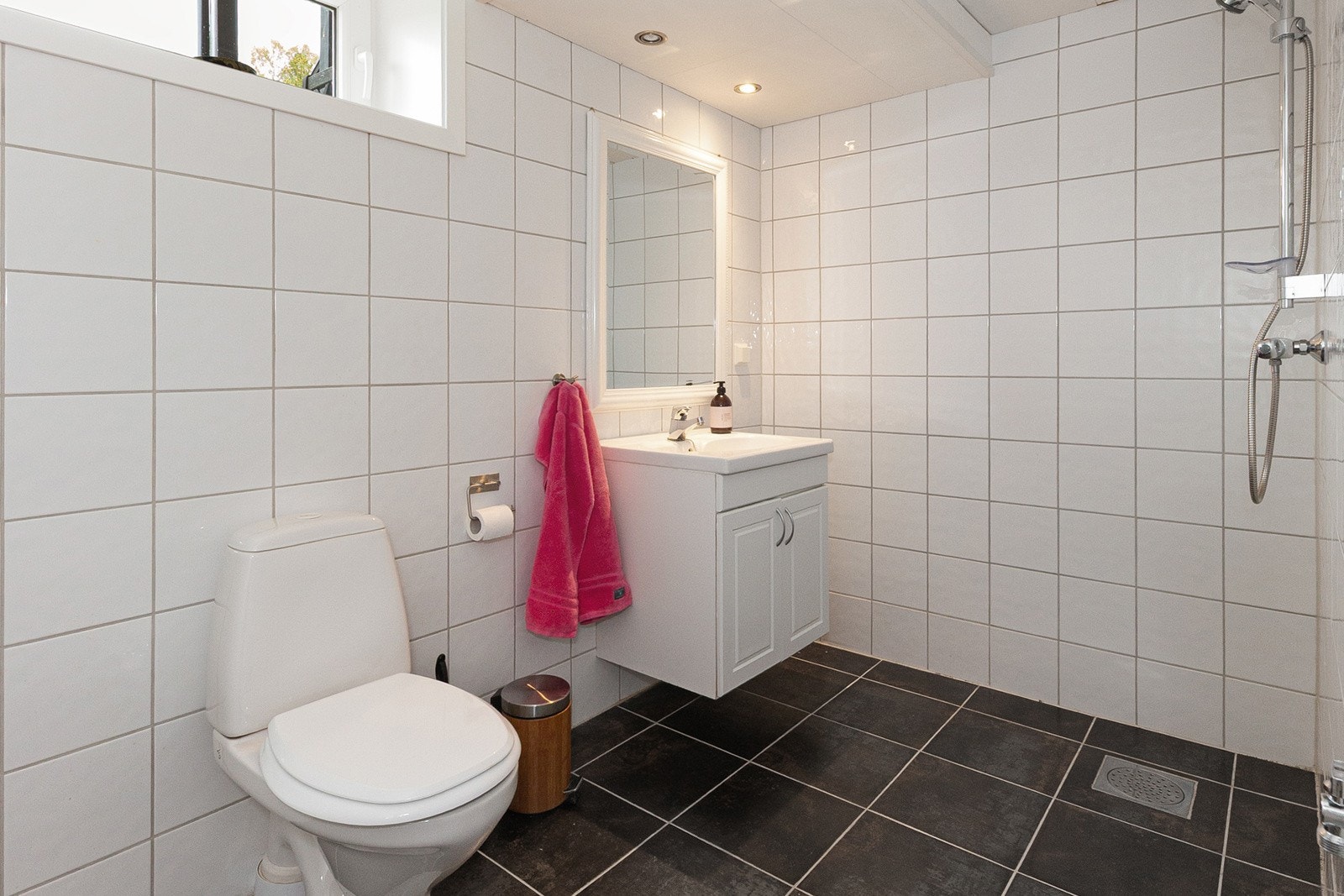 Badet i u.etg. har toalett, åpen dusj, servantskap med nedfelt servant og opplegg for vaskemaskin. Galleribilde