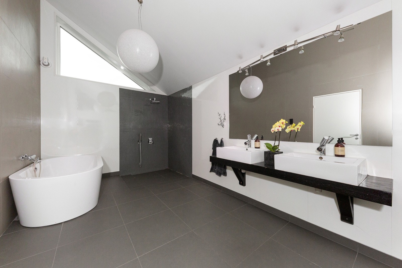 Badet har åpen dusj, frittstående badekar, servantinnredning med 2 servanter og wc. Galleribilde