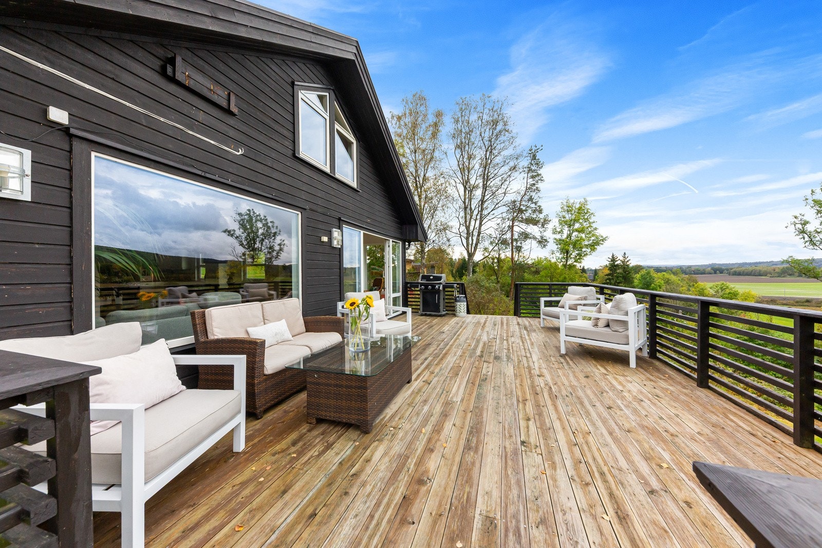 Romslig veranda med plass til flere sittegrupper. Galleribilde