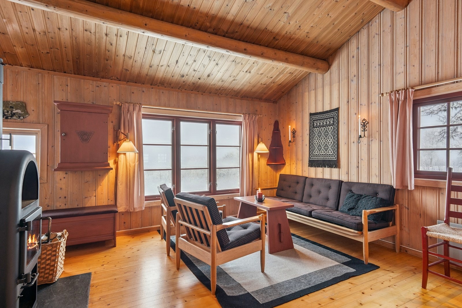 Innvendig er hytta preget av heltre på gulv og panelte vegger og himling, noe som gir en lun og naturlig atmosfære. Galleribilde