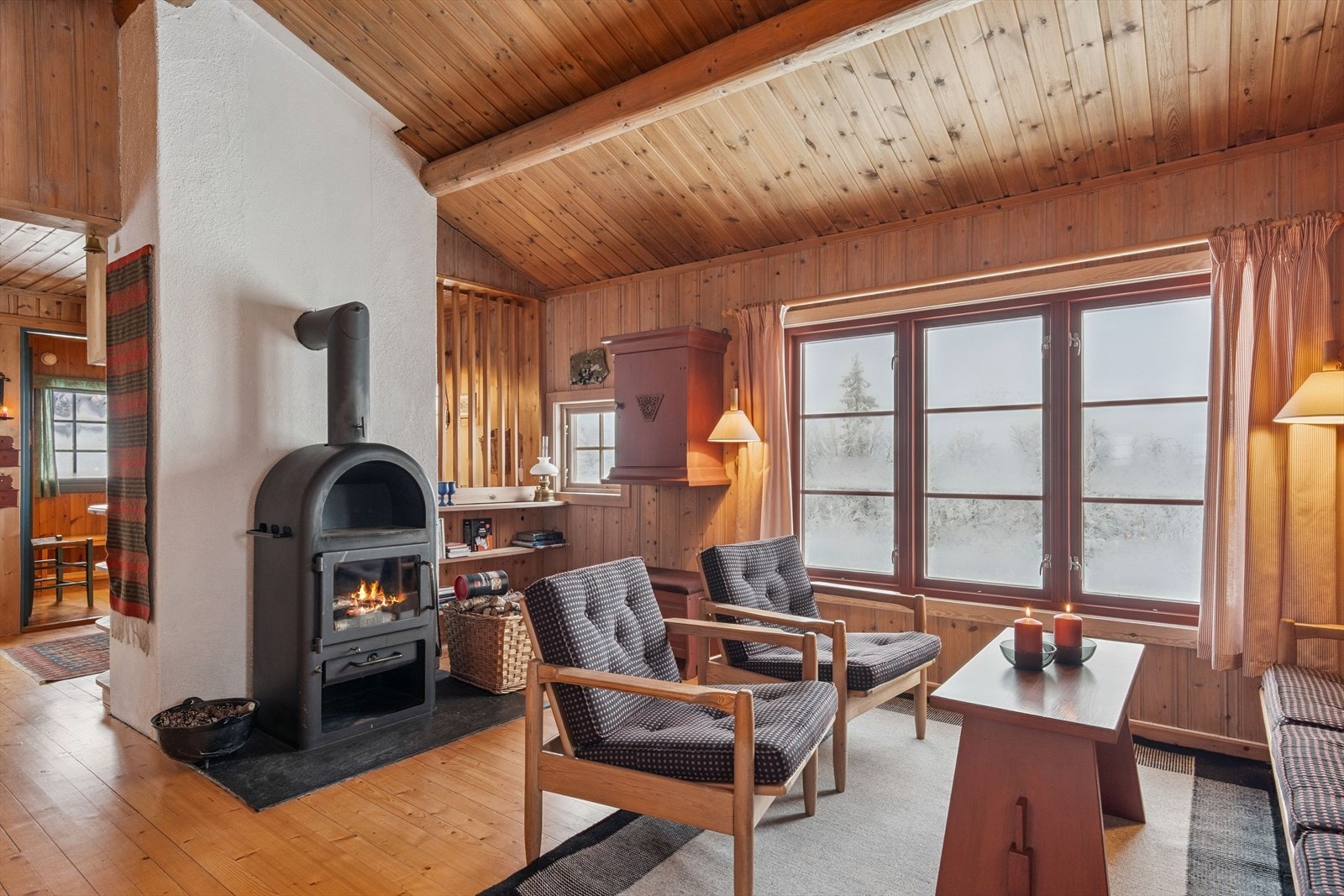 Stua har mønet himling med synlige rundstokker og store vindusflater som slipper inn rikelig med dagslys og gir flott utsikt mot fjellheimen. Galleribilde