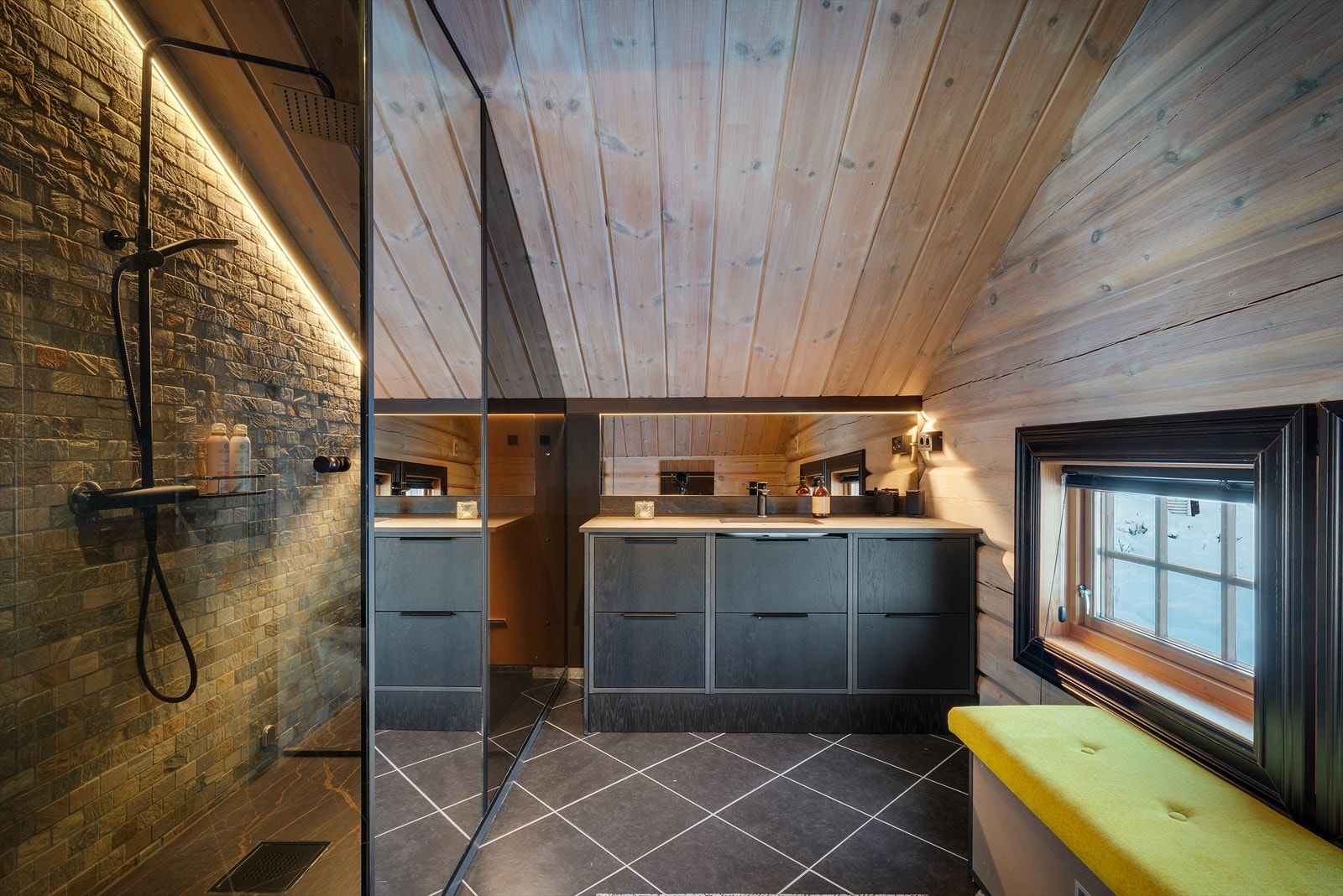 Flisbelagt bad med tømmer og fliser på vegger, samt panel i himling. Galleribilde