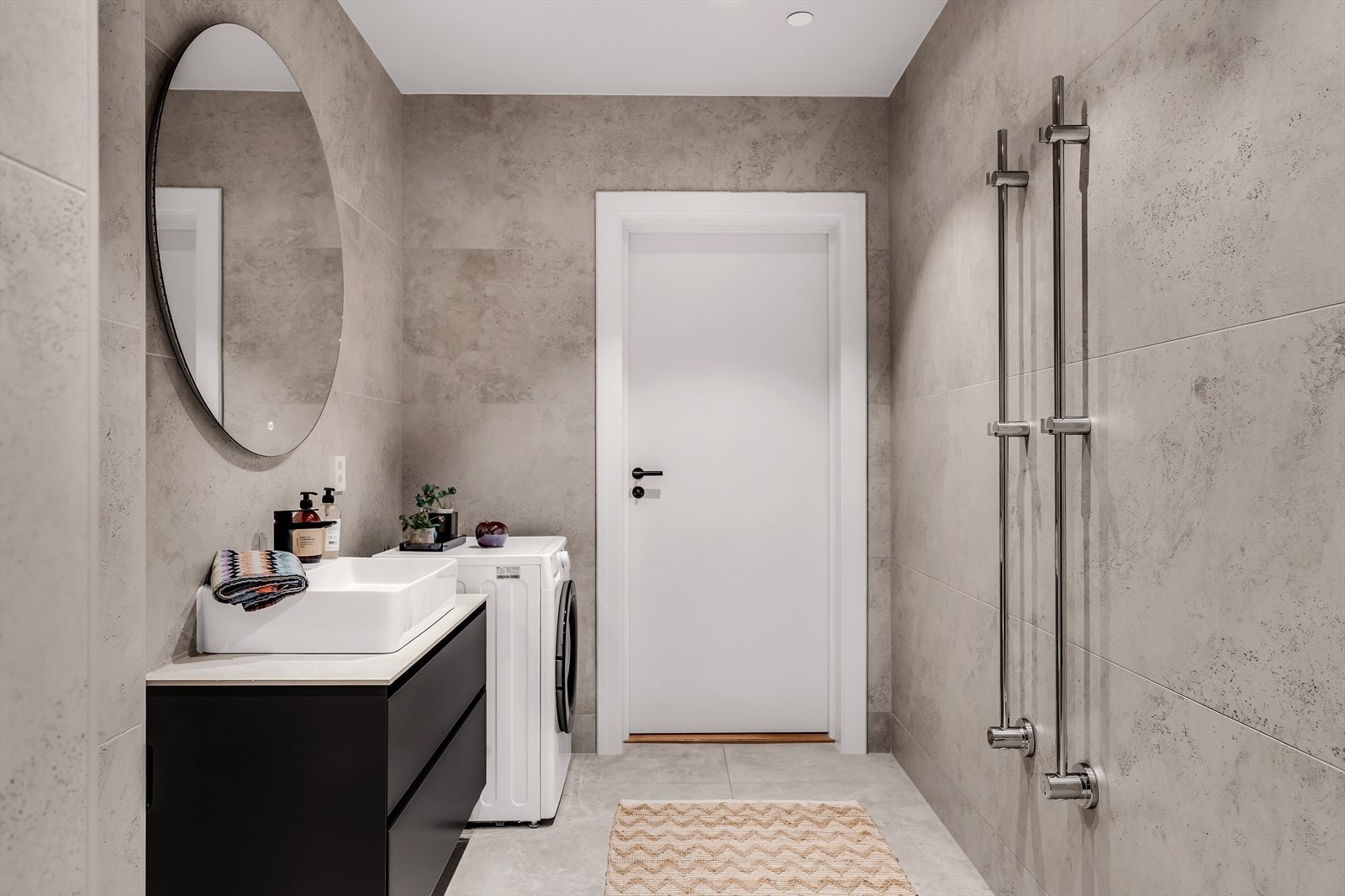 Baderomsinnredning med malte glatte fronter og laminat benkeplate med overliggende servant. Downlights med dim i himling og elektrisk håndklevarmer. Galleribilde