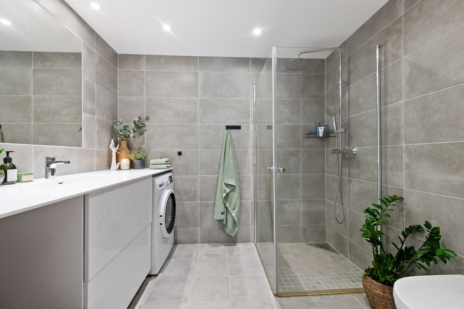 Rommet er utstyrt med et moderne dusjhjørne med innfellbare glassdører og innebygget klosett. Galleribilde