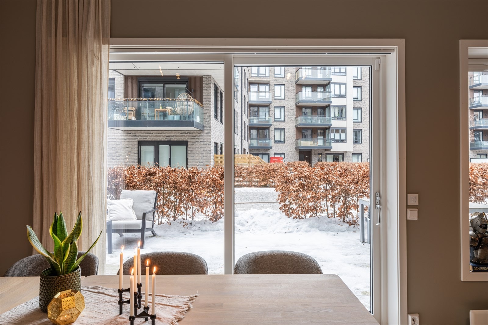 Den store skyvedøren gir rikelig med naturlig lys og skaper en sømløs overgang til markterrassen. Skyvedøren er utstyrt med screens for effektiv solskjerming. Galleribilde