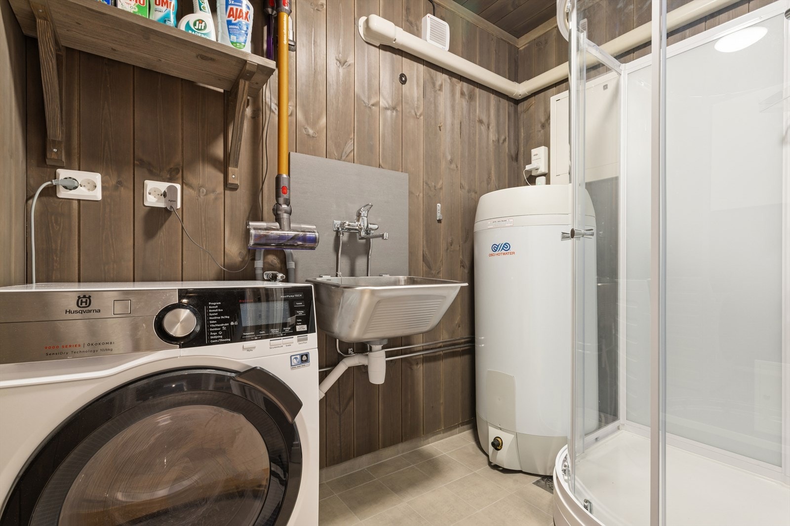 I første etasje finner man også et vaskerom som er innredet med flislagt gulv og panel på vegg. Rommet er ellers utstyrt med utslagsvask, varmtvannsbereder, dusjkabinett og opplegg for vaskemaskin. Galleribilde