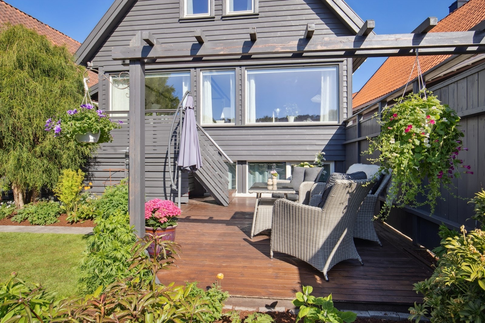 Boligen har flotte og usjenerte uteareal på begge sider av eiendommen med utgang fra stuen Galleribilde