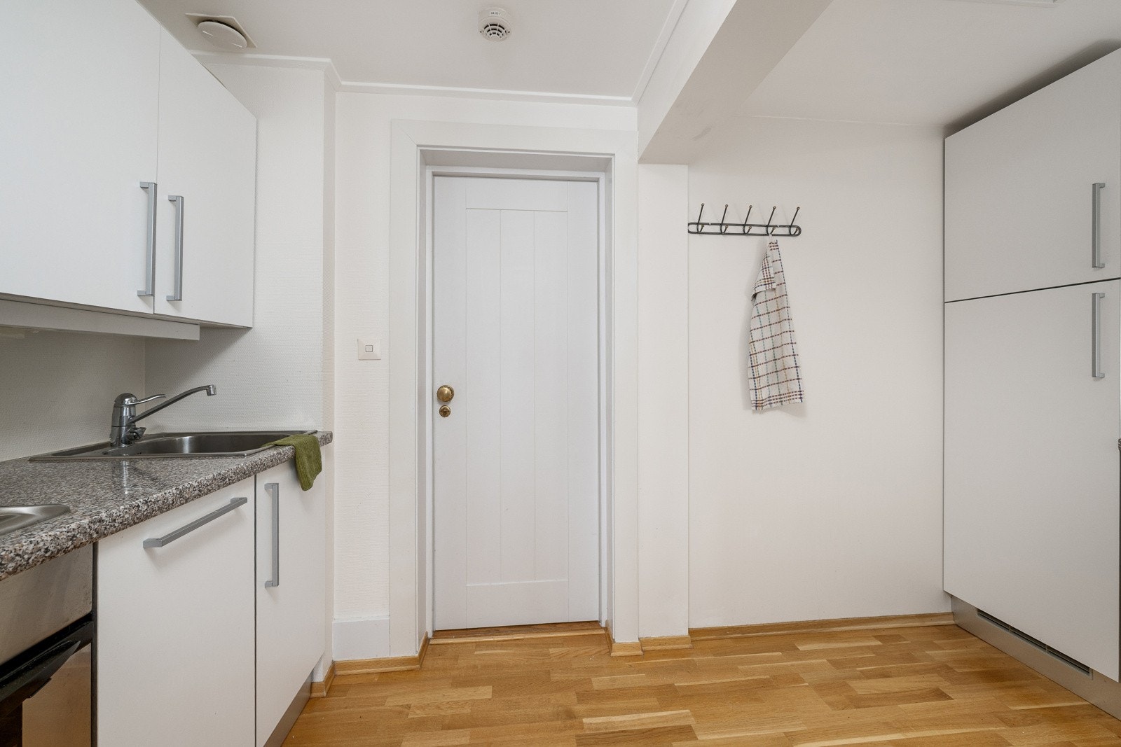 Innredningen har glatte fronter og en laminert benkeplate med integrert kjøkkenkum. Galleribilde