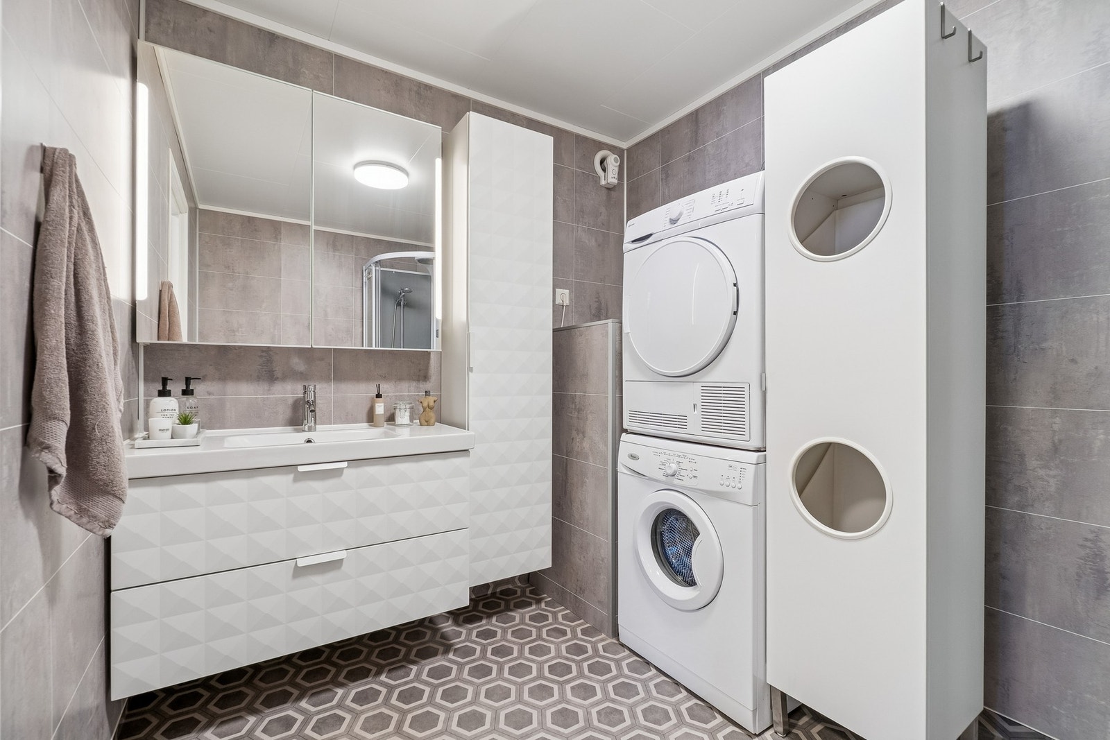 Leilighetens bad har en praktisk beliggenhet ved soverommene, og har plass for både vaskemaskin og tørketrommel. Galleribilde