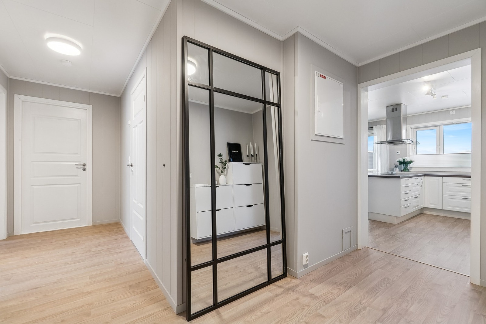 En romslig gang binder rommene i leiligheten sammen. Det er moderne og tidsriktig bruk av farger og materialer som gir leiligheten et helhetlig og gjennomført inntrykk. Galleribilde