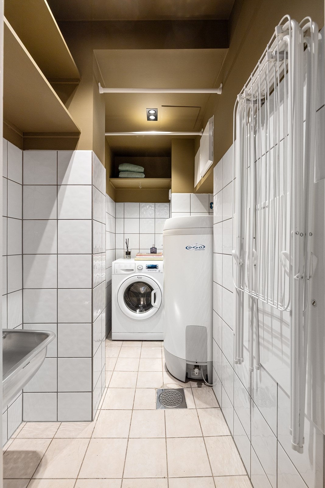 Flislagt, separat vaskerom med vartmvannsbereder, utslagsvask og opplegg til vaskesøyle Galleribilde