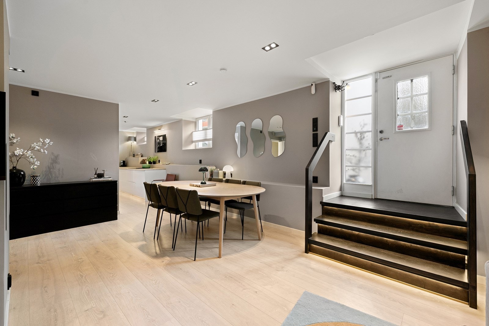Åpen løsning som binder stue og spisestue naturlig sammen med innvendig enkel tretrapp fra ytterdør. Galleribilde