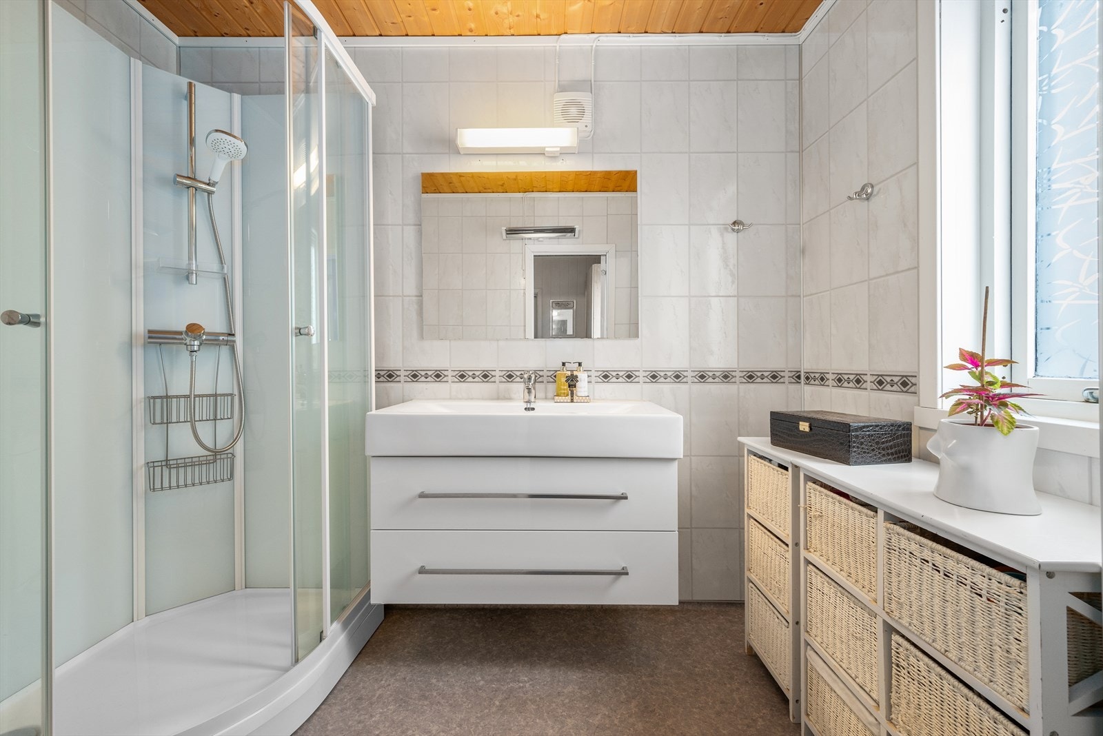 Badet er utstyrt med dusjkabinett, mekanisk avtrekk, baderomsinnredning, og WC. Galleribilde