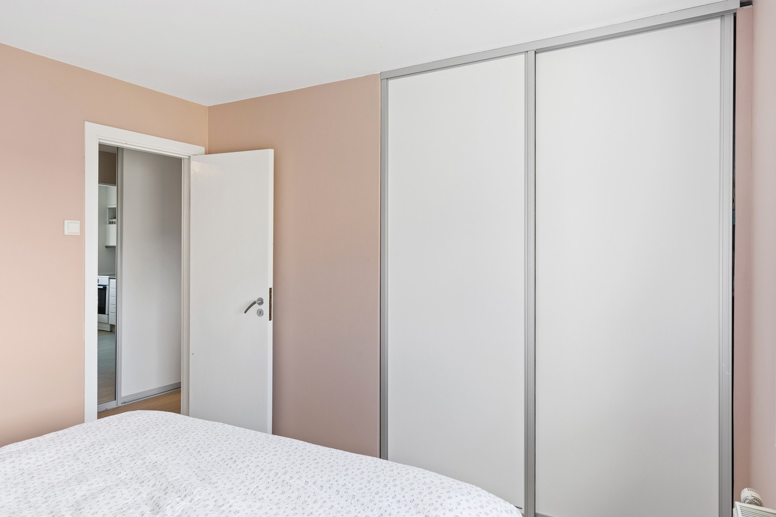 Rommet er innredet med en praktisk skyvedørsgarderobe med hvite, slette fronter som gir et moderne uttrykk og rikelig med oppbevaringsplass. Et lyst og behagelig rom med plass til både seng og nattbord. Galleribilde