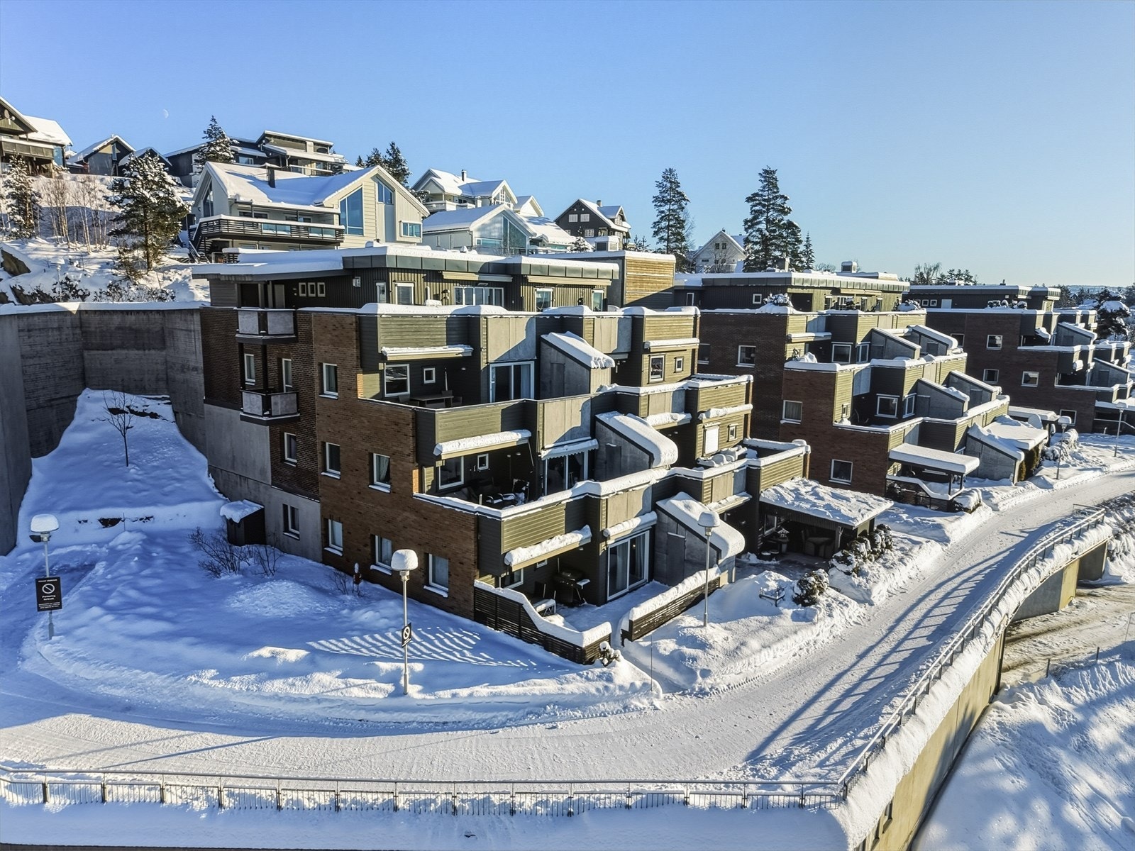Skrånende opparbeidet tomt med beplantning og plenarealer. Asfalterte tilkomstveier. Tomtearealet er et fellesareal for sameiet. Galleribilde