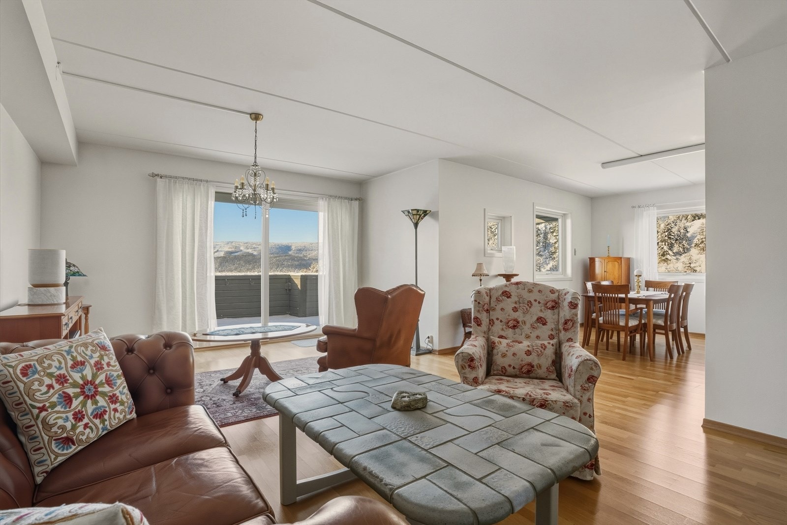 Hyggelig innbydende stue med parkett på gulv og slette, lyse overflater. Galleribilde