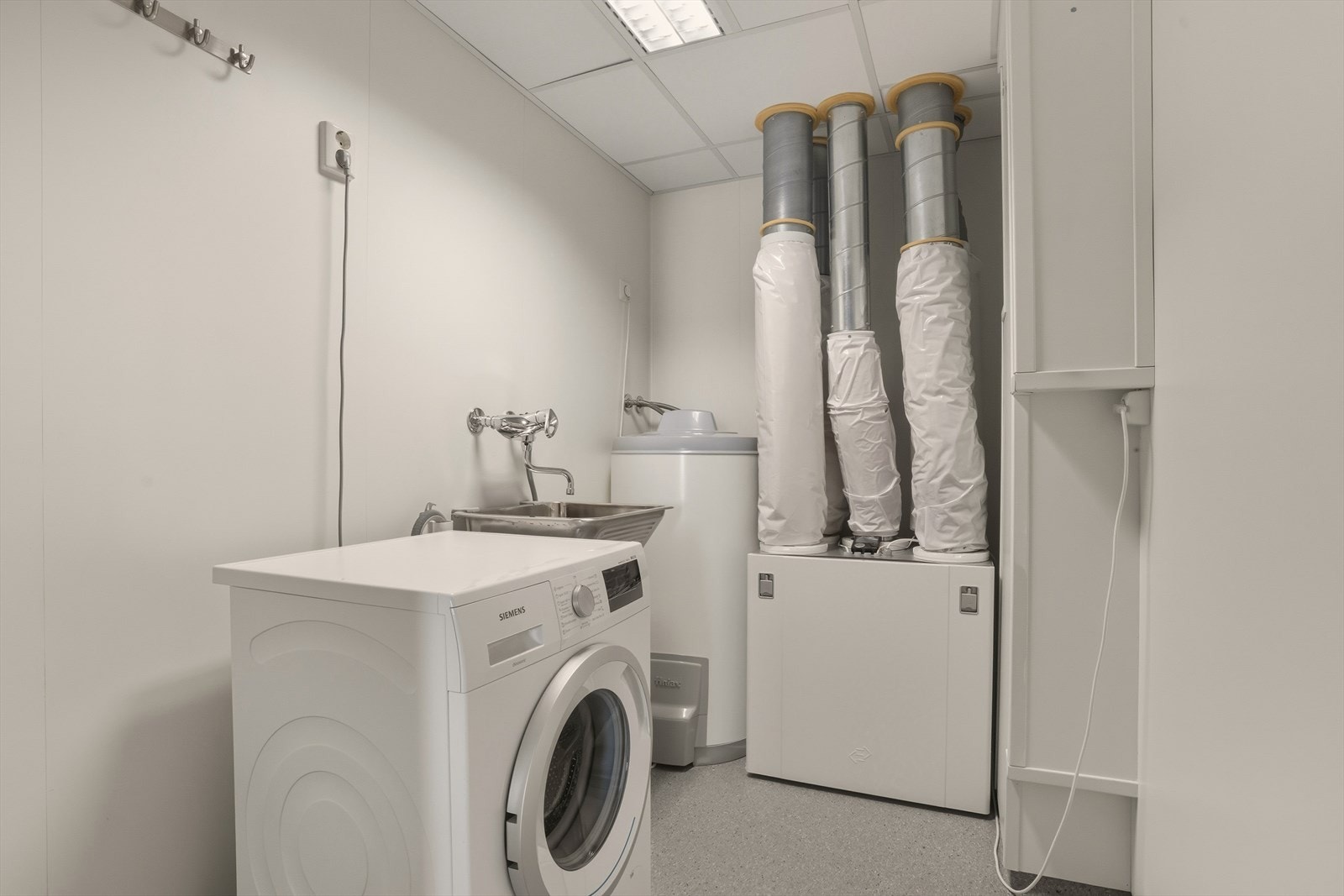 Praktisk innredet vaskerom med utslagsvask, og rommet har opplegg for vaskemaskin. Galleribilde