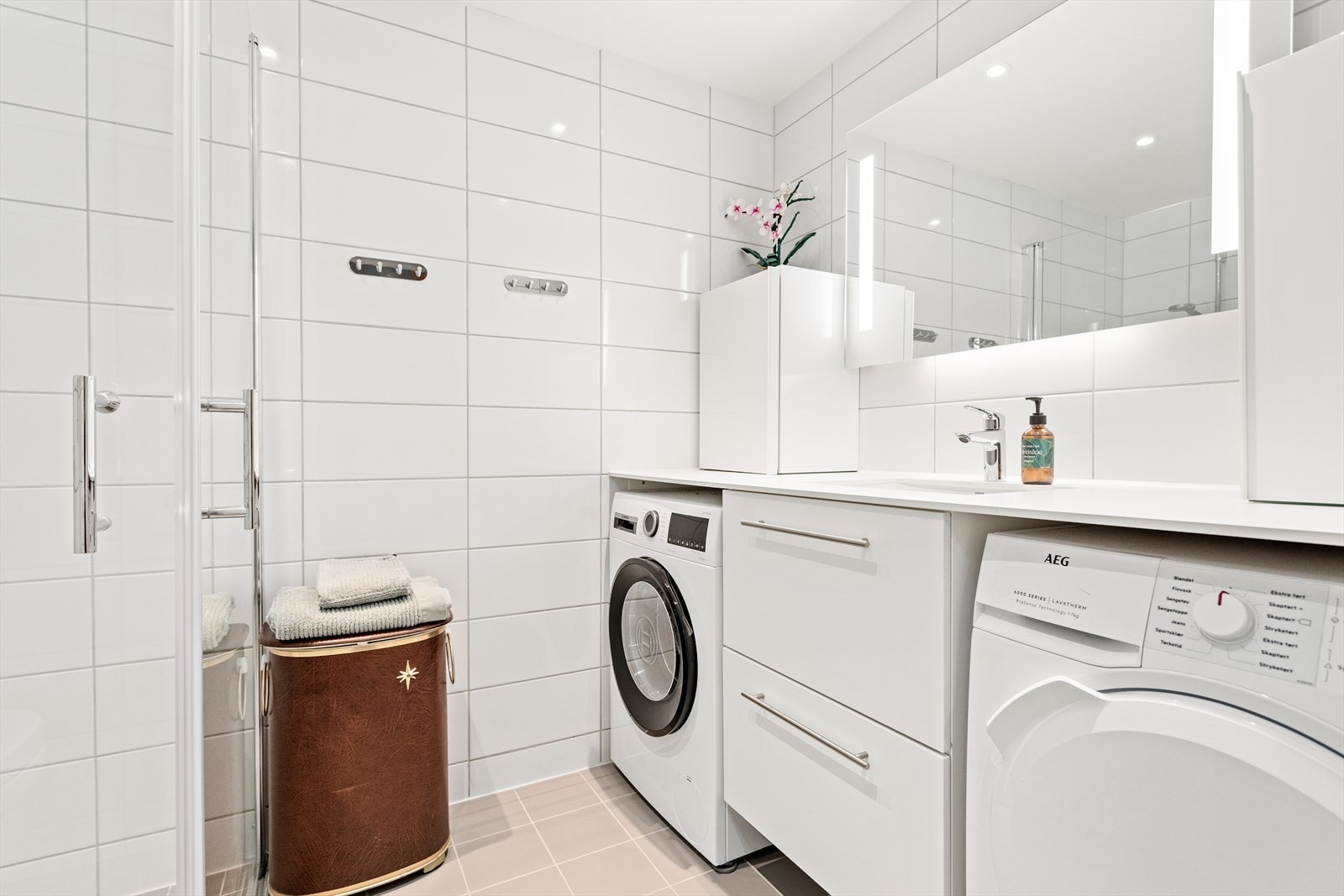 Badet inneheld alt ein treng. Det er nytta flis på golv og veggar, og måla tak. Begge skåpa som står på baderomsbenken er lause og følgjer ikkje med i salet. Galleribilde