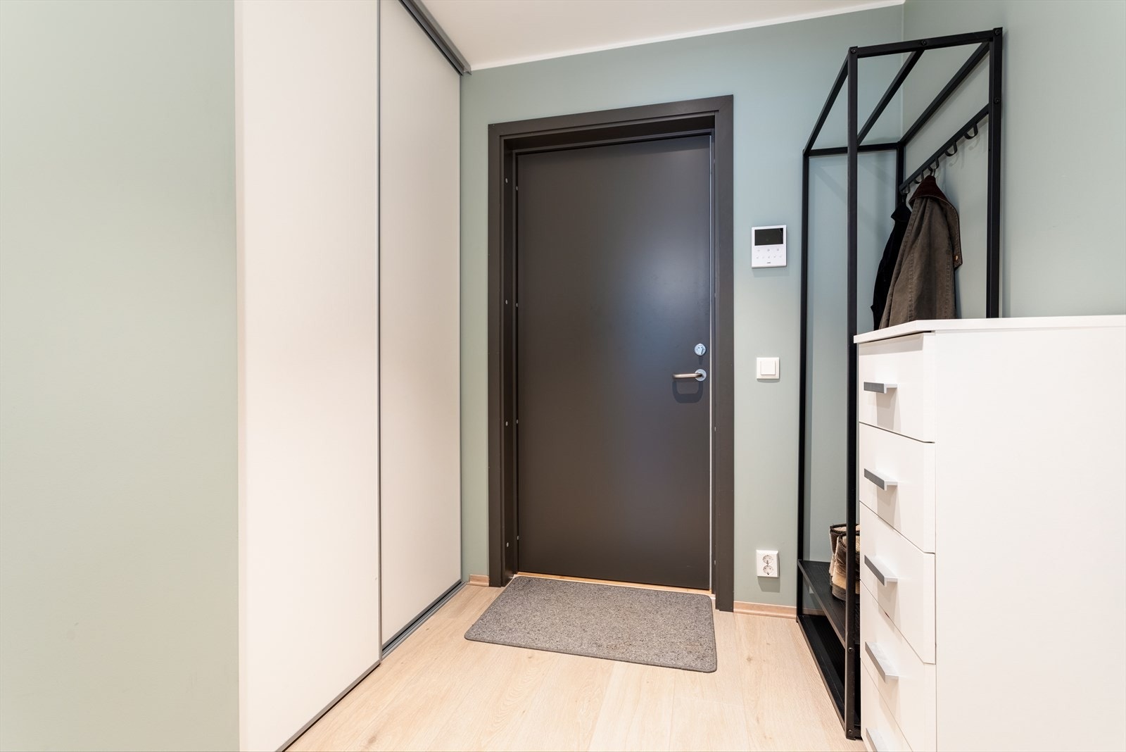 Velkommen inn! Romsleg entré med plass til oppheng av ytterklede, og skjult bak ei skyvedør har du meir praktisk oppbevaringsplass i bod. Galleribilde