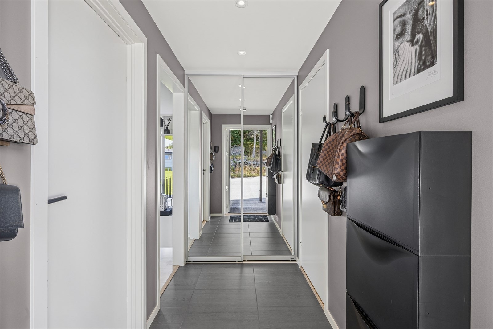 Velkommen inn, entre med flislagt gulv og varme i gulvet. Samt skyvedørs garderobe innerst i rommet som gir dybde i gangen. Galleribilde