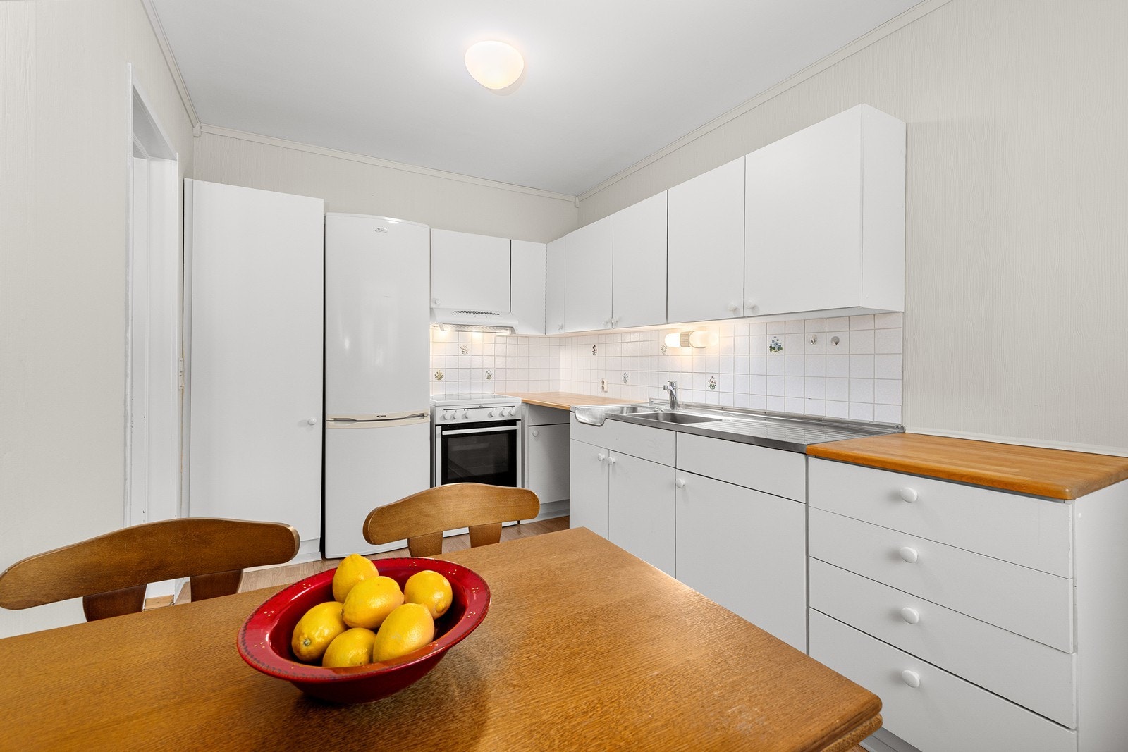 Innredningen har en benkeplate av laminat og avsatt plass til hvitevarer. Galleribilde