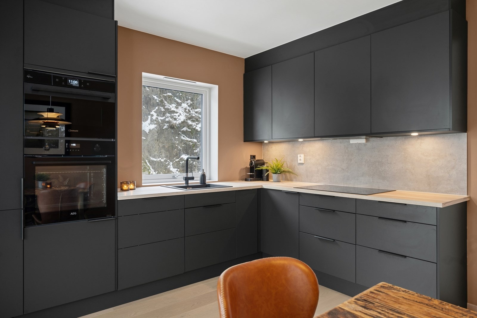 Kjøkkenet fremstår både stilrent og praktisk, med folierte skrog og fronter som gir et moderne uttrykk. Galleribilde