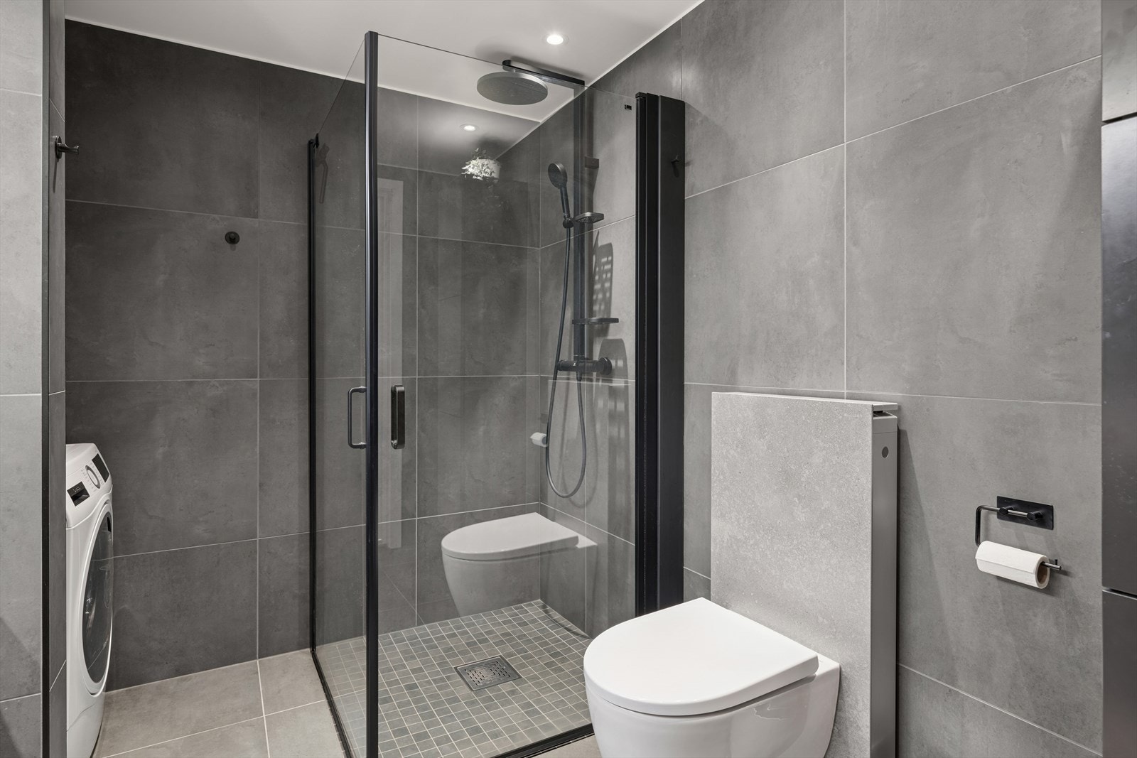 Utstyrt med servant, vegghengt toalett og en romslig dusjsone med dusjvegger som gir et delikat og funksjonelt preg. Det er også opplegg for vaskemaskin. Galleribilde