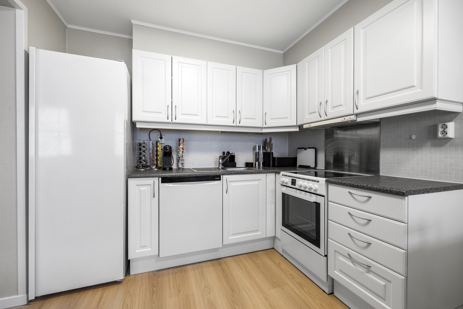 Kjøkkenet er innredet med profilerte fronter og benkeplate i laminat. Galleribilde