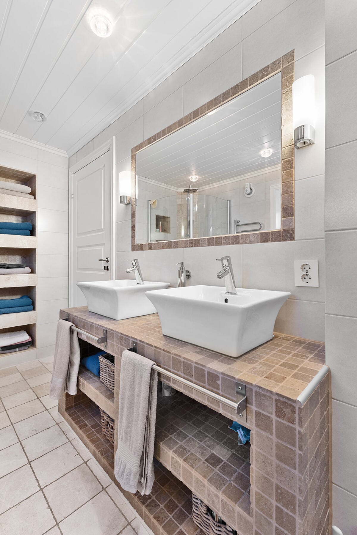 Badet er innredet med dusjkabinett, servant og vegghengt toalett Galleribilde