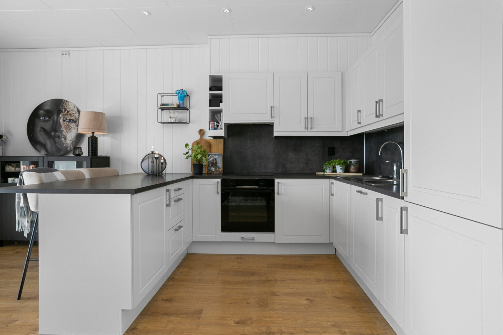 Kjøkkenet har rikelig med lagringsplass og en praktisk barløsning Galleribilde