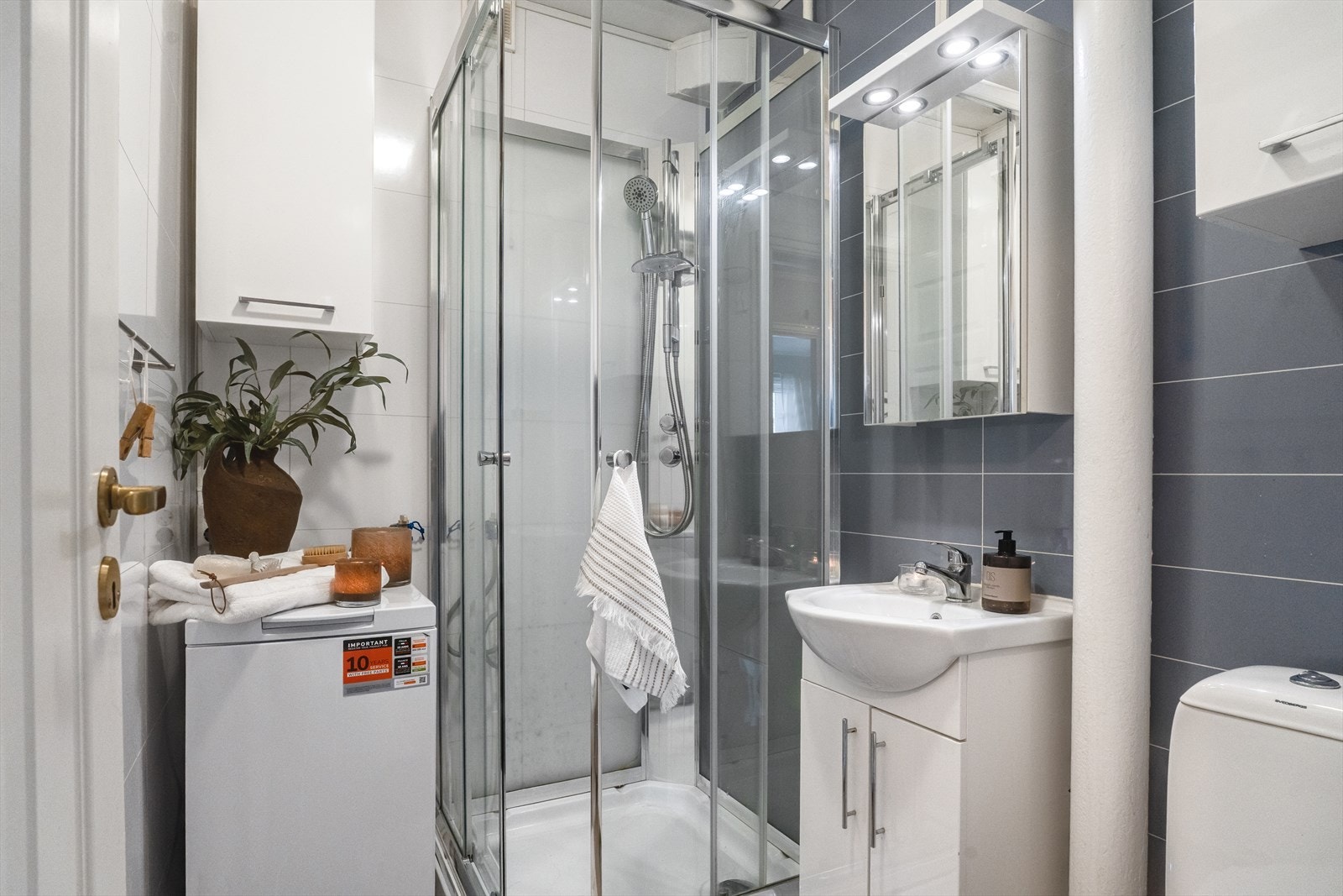 Badet er utstyrt med toalett, dusjkabinett og servant med innredning. Galleribilde