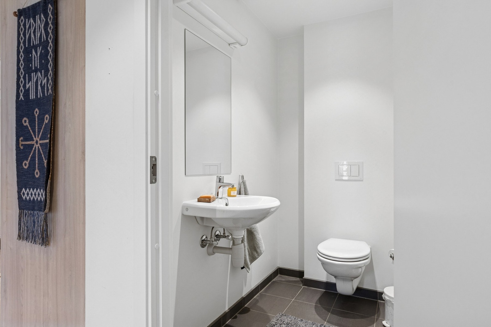 Leiligheten har også separat toalettrom med vegghengt toalett og servant. Galleribilde