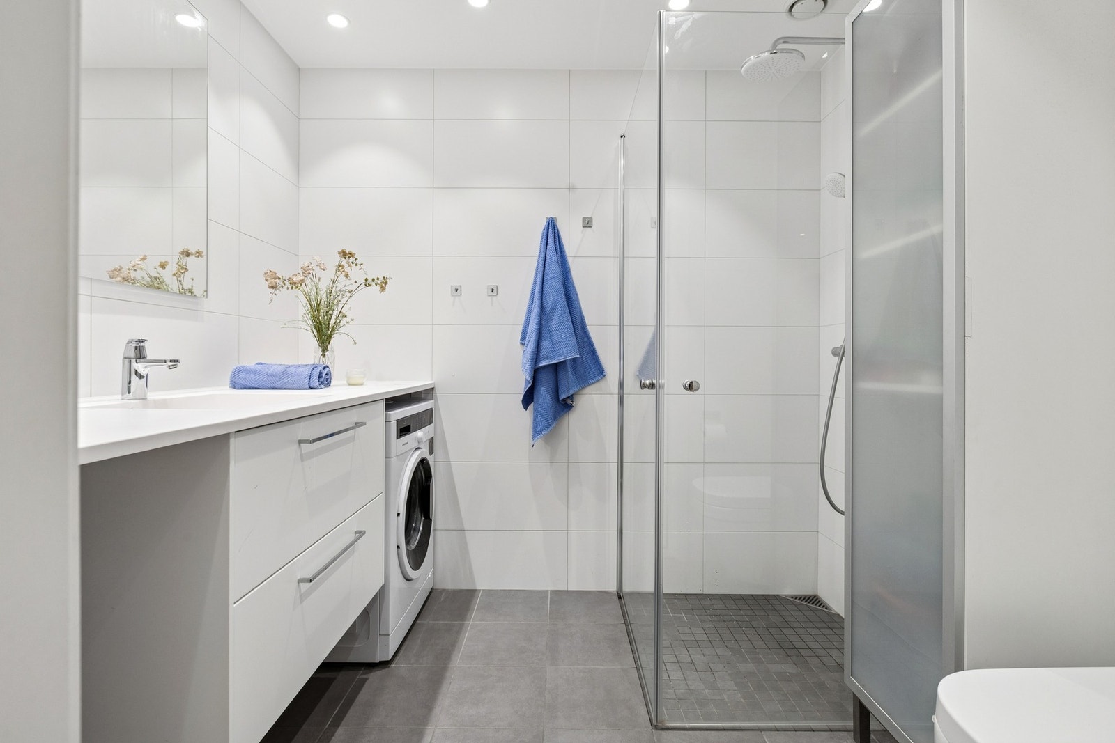 Badet fremstår delikat og moderne med flislagte overflater, behagelig gulvvarme og et tidløst uttrykk. Galleribilde